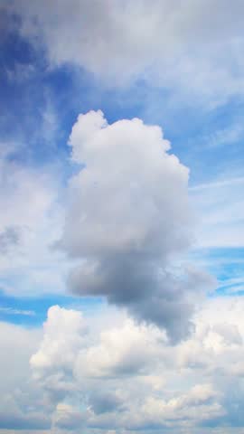 Beautiful fluffy clouds drifting across a bright blue sky during a sunny afternoon in a peaceful outdoor setting. Calm and romantic background with clouds on the weather theme.