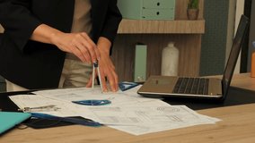 Close-up of mature female e engineer working on new project , creating design and drawing blueprints using drafting tools at office . - Powered by Shutterstock - Get 15% off with code: PIKWIZARD15