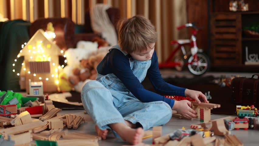 Child, cute boy, playing with toys in a playroom, focus on his feet