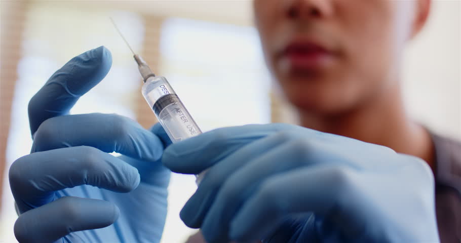 Preparing syringe for medical procedure, healthcare worker wearing gloves. Medicine, injection, safety, sterile, hospital, nurse