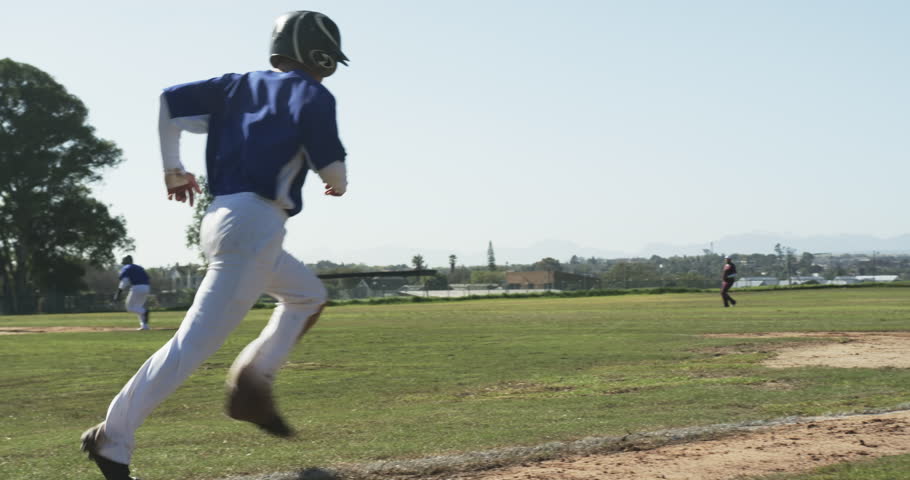 Multiracial male baseball players playing baseball, catching ball, running on a pitch, slow motion. sports, activity, teamwork, competition and baseball.