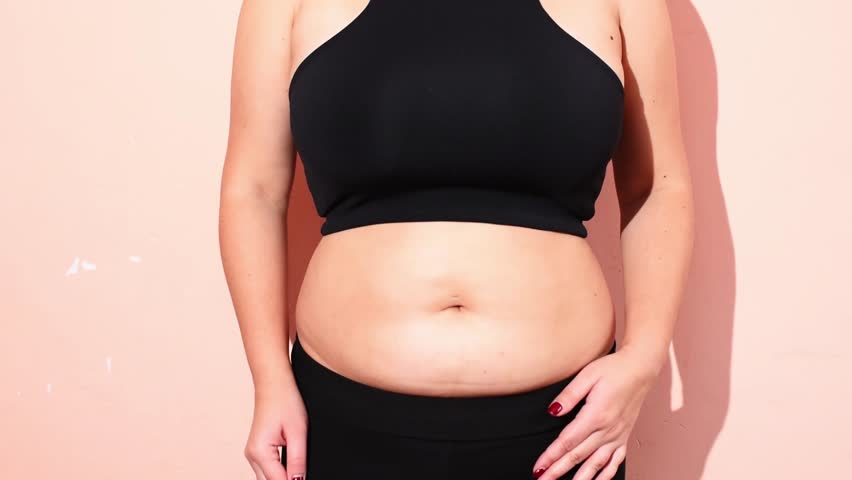 Plump woman touches her belly , weight loss process, women belly fat, postpartum belly horizontal 4k footage. Lifting of the body with sport and fitness. Healthy way of life	