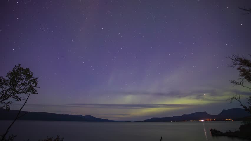 Aurora borealis dancing over a lake in a night timelapse in Abisko, Sweden