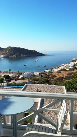 Beautiful terrace with sea view. Ios island, Greece. Blue sea and the blue sky at sunrise. Travel and summer vacation concept. Vertical video
