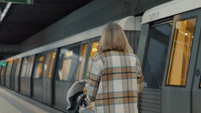 Mother standing near subway platform, pushing stroller while waiting for train, train approaching through bustling urban station with contemporary motion - Powered by Shutterstock - Get 15% off with code: PIKWIZARD15