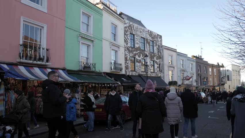 London , London , United Kingdom (UK) - 01 03 2025: Colorful buildings and market stalls on Portobello Road, London, bustling with people