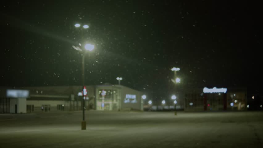 A Cinematic Shot Of Street Pillars Lit By Soft Streetlights, With Snowflakes Gently Falling Overhead. This Peaceful Winter Scene Captures The Calm Beauty Of Snowfall At Night.