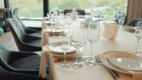 Table with a white tablecloth and a number of plates, forks, knives, and wine glasses - Powered by Shutterstock - Get 15% off with code: PIKWIZARD15