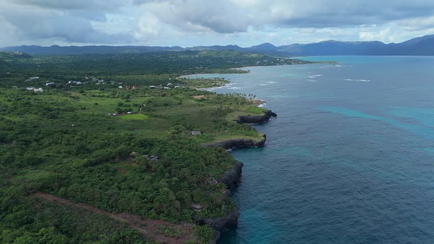 Caribbean landscape, jagged coast and cliffs along tropical sea, Las Galeras, Samana in Dominican Republic. Aerial forward