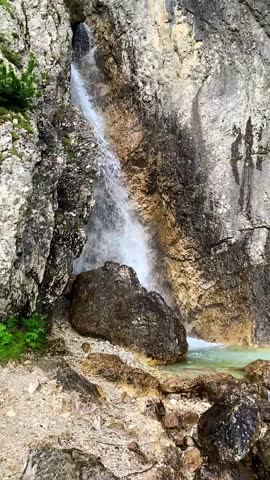 Water flowing and falling down on the rock in the Trentino Mountains