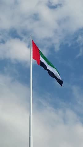 UAE flag waving in the blue sky, national symbol of UAE. High quality 4k footage.