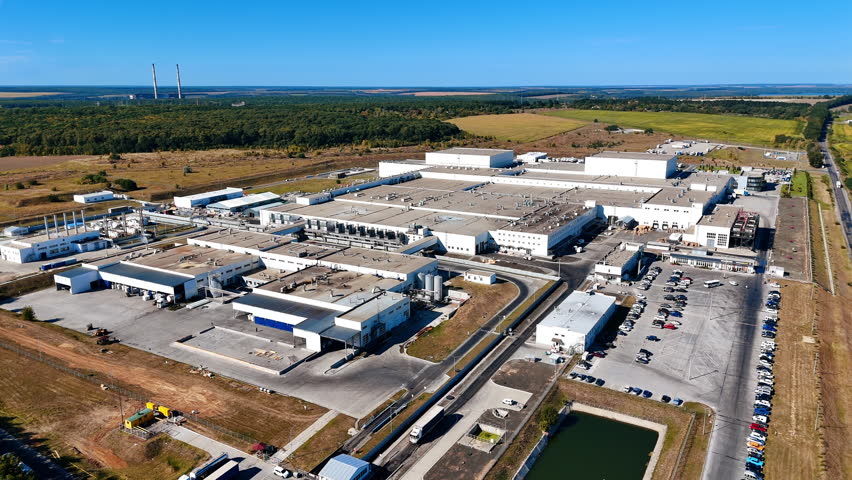 Food factory territory outside a big city. Aerial perspective on the premises of industrial plant in the surrounding of nature.