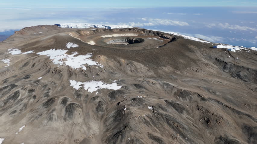 Drone shot of Uhuru Peak on Mount Kilimanjaro with the volcanic crater in the distance. Aerial shot