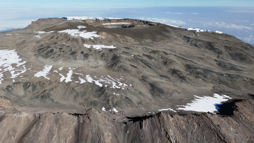 Drone shot of Uhuru Peak on Mount Kilimanjaro with the volcanic crater in the distance. Aerial shot