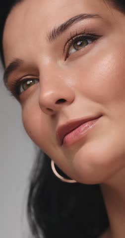 A slow-motion close-up of a confident woman with flawless makeup, featuring glowing skin, defined eyeliner, and glossy lips. Perfect for beauty, cosmetics, and skincare concepts. 