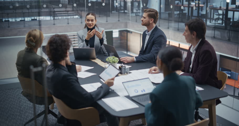 Diverse Business Team Engaged in Lively Discussion During a Brainstorming Session in a Glass Conference Room. Creative Ideas Flow as Male and Female Team Members Share Their Insights and Perspectives