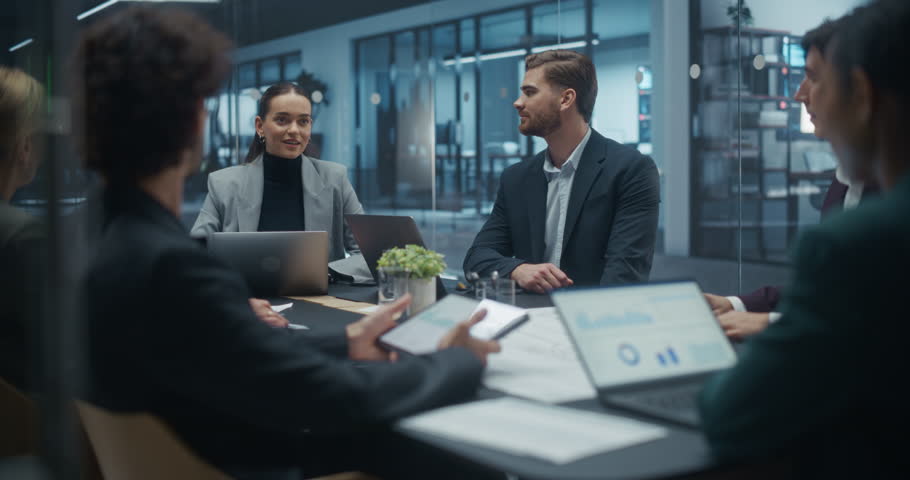 Portrait of an Expert Analyzing Data and Sharing Insights During a Meeting with Partners in a Modern Glass Meeting Room. Managers Identifying Trends, Business Challenges and Development