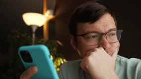 Different facial expressions of a man wearing glasses and using a smartphone with a turquoise cover in his hands in a domestic environment with a lamp and plants in the background - Powered by Shutterstock - Get 15% off with code: PIKWIZARD15