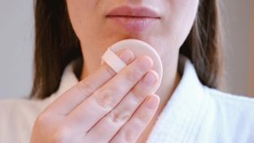 Young woman applying brown cushion on face with pad close-up front view. - Powered by Shutterstock - Get 15% off with code: PIKWIZARD15