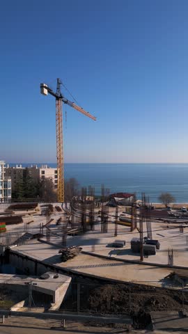 New hotel or residential complex under construction on the picturesque Kabakum Beach near Varna, Bulgaria. Tower cranes, metal structures, and the seaside view define this vibrant sunny worksite