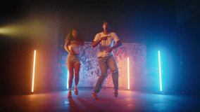 Positive male and female dancers moving actively on dance floor in studio. Full-length portrait of African American people jumping and dancing, good mood and emotions, creative hobby and leisure - Powered by Shutterstock - Get 15% off with code: PIKWIZARD15