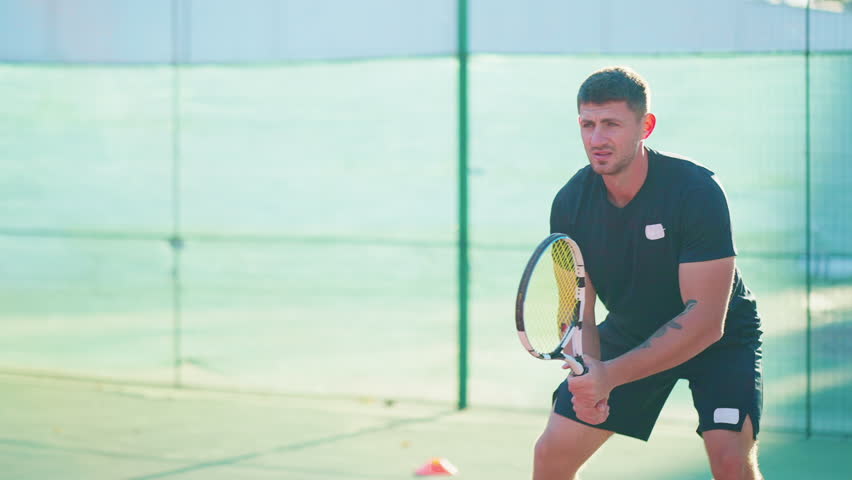 athletic man playing tennis outdoors, handsome sportsman jumping and beating ball by tennis racket, medium portrait shot in motion, sport and hobby in weekend in summertime