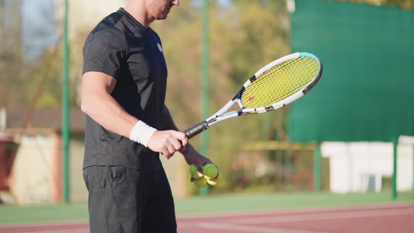 Man training low volley shot in tennis. Sportsman practicing ball shots, low serve during professional sport workout on court outdoors. Exercising, practice in tennis game. Hobby, sports concept.