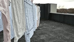 Laundry drying naturally on a rooftop clothesline on a cloudy day, promoting sustainability and eco-conscious living by reducing energy usage. An example of simple, eco-friendly habits. - Powered by Shutterstock - Get 15% off with code: PIKWIZARD15