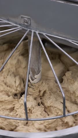 Industrial Electric Spiral Dough Mixer Machine Kneading Bread Dough at the Bread Factory. Wholegrain Bread Dough Kneading Inside the Industrial Dough Mixer Machine. Industrial Bakery Equipment.