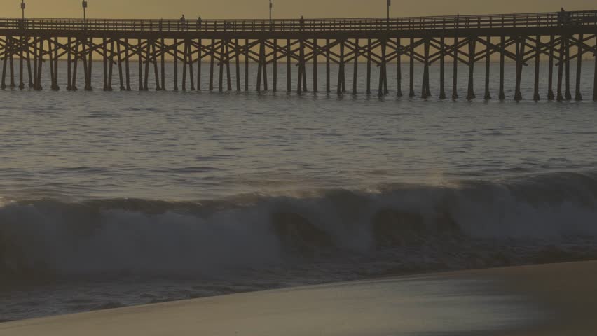 The Long Beach Pier during sunset, calm waves, and serene ocean mood in California