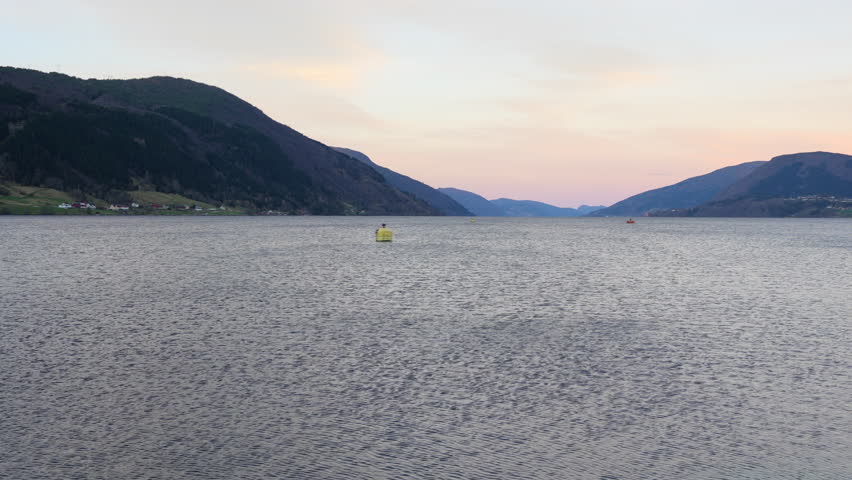 Breathtaking autumn scenery in Nordfjord, Norway, showcasing serene fjords, a tranquil bay, and vibrant fall foliage against majestic mountains. 