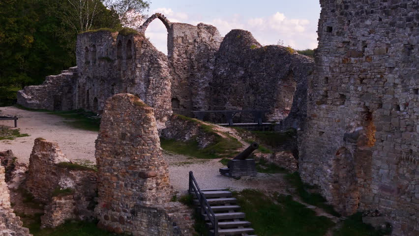 Aerial flying backwards revealing ruins of Koknese Castle on banks of Daugava River