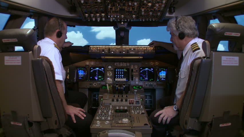 Boeing 747 flight crew turn and pose for the camera as clouds go by outside the