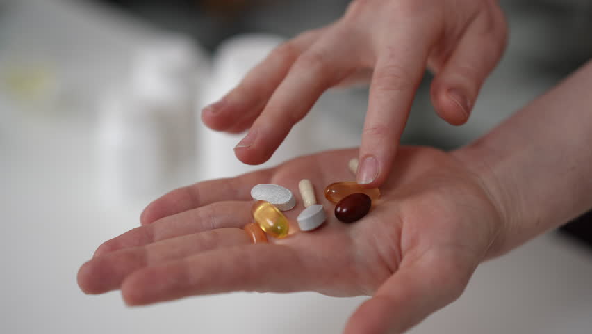 A closeup view showcasing a variety of dietary supplements being held, emphasizing health and overall wellness