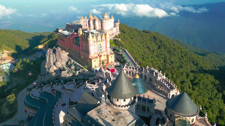 Aerial view of Ba Na Hills featuring a fairytale castles nestled among lush green mountains.