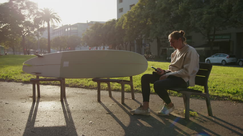 Surfer man walking to the beach at sunset preparing for surfing training and search for waves in Barcelona, spain, water, ocean exercise in sea with board, athletic male holiday or travel in vacation.