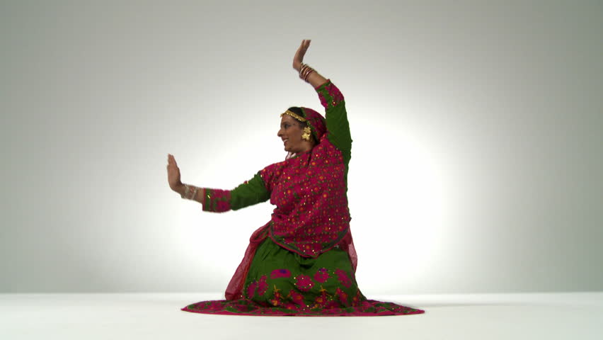Indian girl in traditional folk dance costume ends her dance and strikes a pose