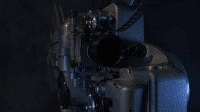 Projectionist hand starts vintage 16mm film projector. Light source beams into camera. - Powered by Shutterstock - Get 15% off with code: PIKWIZARD15