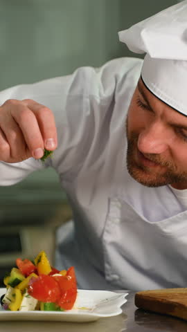 Chef Sprinkling Salt on a Freshly Plated Vegetable Dish