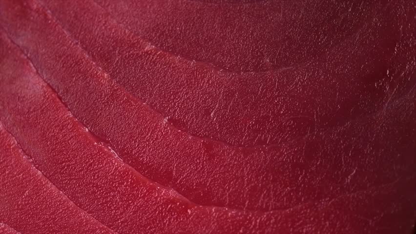 Tuna texture background, steak. Fresh raw tuna fish fillet close-up, sea fish rotating backdrop, top view, flat lay. Fresh sliced bluefin tuna raw meat texture macro shot