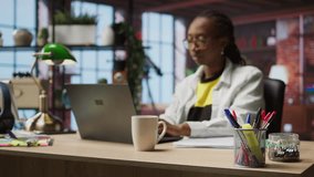 Bookkeeper in home office reviewing tax forms, reading reports on laptop and writing down information. Remotely working accountant managing finances remotely, taking notes, camera A - Powered by Shutterstock - Get 15% off with code: PIKWIZARD15