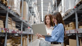 In a bustling warehouse filled with shelves of products, two women share insights and strategies while working on a laptop computer, demonstrating teamwork and efficiency in their tasks. - Powered by Shutterstock - Get 15% off with code: PIKWIZARD15