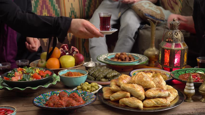 Muslim family gathered around a table during Ramadan, sharing a joyful Iftar meal with traditional dishes and dates, symbolizing togetherness, faith, and celebration of the holy month