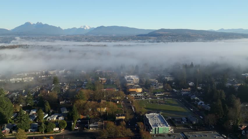 Fog And Clouds Over The Fort Langley Township At Sunrise In BC, Canada. - aerial shot