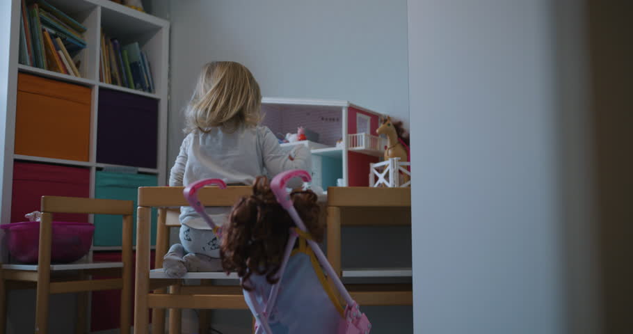 Back of a little girl playing on her own in kids room