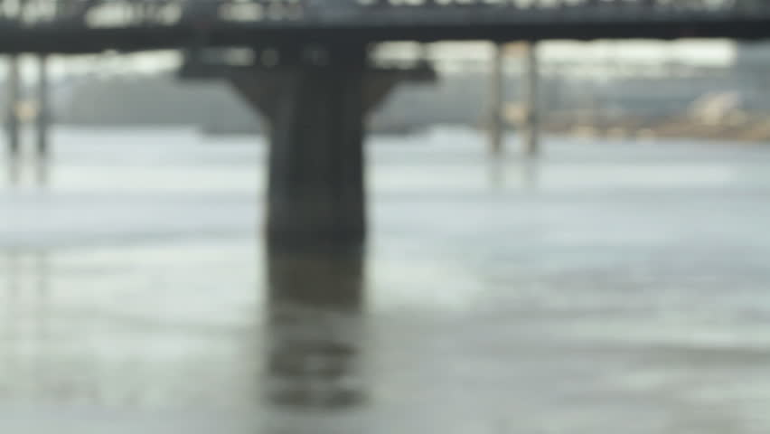 Close up, pan to an attractive older Asian-American standing by the Willamette River in Portland, Oregon.
