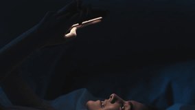 Romantic chat. Night online. Dating app. Relaxed happy woman in love smiling reading message on phone in bed late in dark bedroom. - Powered by Shutterstock - Get 15% off with code: PIKWIZARD15