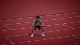 An Athlete is Performing Squats on a Running Track for Their Fitness Training Routine - Powered by Shutterstock - Get 15% off with code: PIKWIZARD15