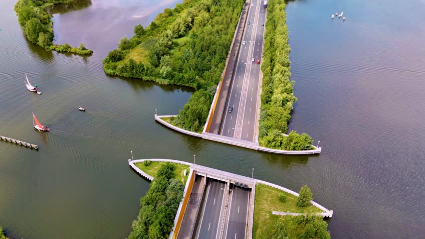 Experience the stunning Veluwemeer Aqueduct as vehicles gracefully cross under the water. Boats glide above this remarkable structure, showcasing the beauty of Dutch engineering and nature.