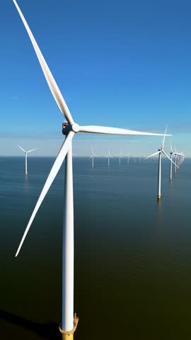 A stunning view of multiple wind turbines standing tall in the waters of the Netherlands, capturing clean energy. These modern giants symbolize the shift towards sustainable electricity generation.